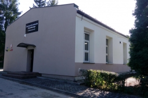 Budynek Centrum Kształcenia Zawodowego w Bażanowicach, widok z zewnątrz. Elewacja jasna, schody wejściowe po lewej stronie.