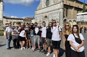 Grupa uczniów z Zespołu Szkół Technicznych i Ogólnokształcących w Skoczowie pozuje przed Bazyliką Santa Maria Novella we Florencji. Uczniowie uczestniczą w miesięcznych praktykach zawodowych we Włoszech w ramach projektu dofinansowanego z Funduszy Europejskich dla Rozwoju Społecznego 2021-2027. Zdjęcie przedstawia młodzież w słonecznej aurze, gotową do zwiedzania miasta i odkrywania dziedzictwa kulturowego Włoch.