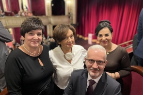 Cztery osoby pozują w sali teatralnej: Danuta Łabaj przewodnicząca Komisji Edukacji Janina Żagan Starosta Cieszyński Lilla Salachna Brzoza wiceprzewodnicząca komisji edukacji i Mieczysław Szczurek Wicestarosta. W tle widoczna jest scena z czerwoną kurtyną, balkon oraz siedząca publiczność.