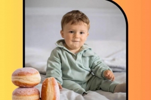 Mały chłopczyk siedzący na łóżku, ubrany w miętowy dres. W lewym dolnym rogu grafiki trzy pączki posypane cukrem pudrem. Tło w odcieniach żółto-pomarańczowego gradientu z napisem „BOHATEROWIE 5 EDYCJI” u góry oraz „LEON DZIEDZIC” na dole.