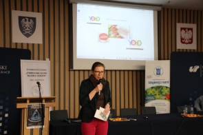 Prelegentka, Bogusława Donocik, przemawia podczas konferencji dla uczniów, w tle ekran z prezentacją.