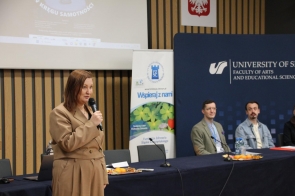 Podsekretarz stanu w Ministerstwie Edukacji Narodowej, wiceministra Paulina Piechna-Więckiewicz trzyma mikrofon, w tle prezentacja.