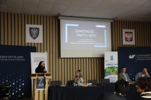 Prelegentka, dr Ilona Fajfer - Kruczek, przemawia podczas konferencji dla uczniów, w tle ekran z prezentacją.