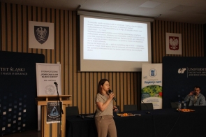 Prelegentka, Martyna Wachtarczyk, przemawia podczas konferencji dla uczniów, w tle ekran z prezentacją.
