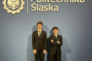 Dwóch mężczyzn w garniturach stoi na tle ściany z napisem „Politechnika Śląska” i logo.