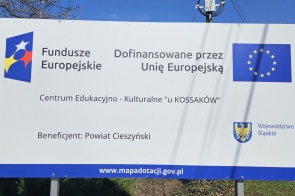 Tablica informacyjna z logotypami Funduszy Europejskich i Unii Europejskiej, dotycząca projektu „Centrum Edukacyjno-Kulturalne u Kossaków”.