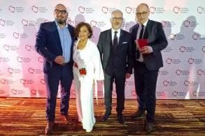 Cztery osoby pozują do zdjęcia na tle ścianki z napisem „Związek Powiatów Polskich”. Wszyscy są ubrani elegancko.