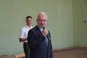 Mieczysław Szczurek Wicestarosta Cieszyński przemawia do mikrofonu, a za nim stoi mężczyzna w koszuli. Na podłodze przy ścianie znajdują się pnie drzew a z tyłu widać mikrofon na stojaku.