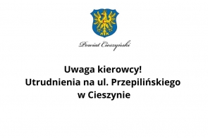 Komunikat graficzny Powiatu Cieszyńskiego zawiadamia kierowców o utrudnieniach w ruchu drogowym na ul. Przepilińskiego w Cieszynie. Przekaz ma charakter ostrzeżenia i informuje o planowanych robotach drogowych w tej części miasta.