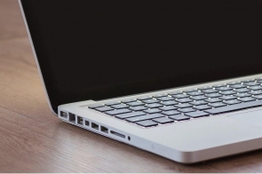 Fragment komputera - laptopa leżącego na biurku