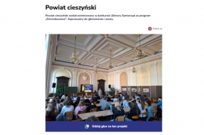 U góry widoczny nagłówek Powiat Cieszyński z informacją o nominacji do konkursu,  poniżej zdjęcie sali wykładowej z wysokim, dekoracyjnym sufitem i żyrandolami, wypełniona siedzącymi uczniami w stronę ekranu z prezentacją. Na dole przycisk "Oddaj głos na ten projekt".