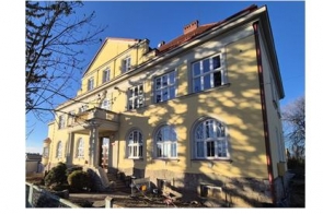 Jasno żółty budynek Zespołu Szkół Przyrodniczo-Technicznych w Międzyświeciu. 