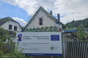 Tablica informacyjna projektu współfinansowanego ze środków Unii Europejskiej zamontowana na ścianie budynku. Widoczne są logotypy programu Fundusze Europejskie, Rzeczypospolitej Polskiej, Unii Europejskiej oraz Województwa Śląskiego wraz z informacjami o realizowanym projekcie.