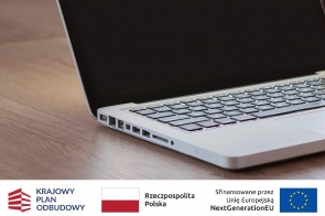 Grafika przedstawia zbliżenie na laptop leżący na drewnianym biurku. Na dole widoczne są logotypy.
