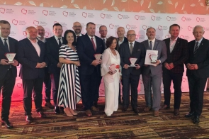 Grupa osób pozuje do zdjęcia na tle ścianki z napisem „Związek Powiatów Polskich”. Część osób trzyma statuetki i dyplomy.
