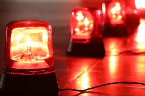 Czerwone lampy ostrzegawcze świecą na ciemnym tle. Na pierwszym planie widoczna jest jedna lampa, a w tle kolejne rozświetlone sygnały.