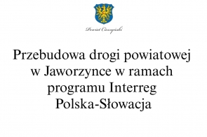 Czarny napis na białym tle: Przebudowa drogi powiatowej w Jaworzynce w ramach programu Interreg Polska-Słowacja, w górnej części Herb Powiatu Cieszyńskiego.