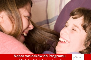Dwie uśmiechnięte osoby – kobieta i dziecko z niepełnosprawnością – cieszą się wspólną chwilą. Na dole czerwony pasek z białym napisem: Nabór wniosków do Programu "Opieka Wytchnieniowa", z logo PCPR w Cieszynie.