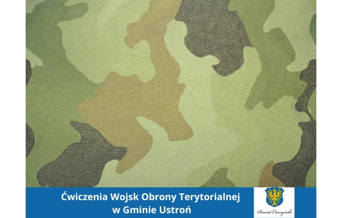 Na tle wzoru moro w odcieniach zieleni, brązu i czerni widnieje niebieski pasek, w którym umieszczono biały napis informacyjny oraz herb Powiatu Cieszyńskiego. Kompozycja nawiązuje do tematyki wojskowej.