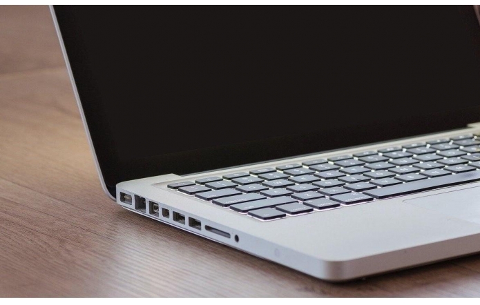 Fragment komputera - laptopa leżącego na biurku