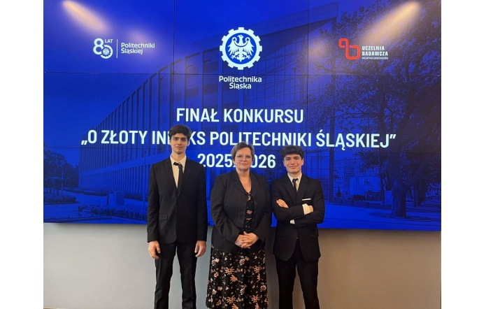Trzy osoby stoją przed ekranem z napisem o finale konkursu Politechniki Śląskiej. Dwóch mężczyzn w garniturach po bokach, Regina Rakowska Dyrektor II LO im.Mikołaja Kopernika pośrodku.