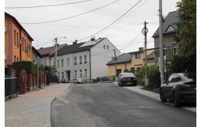Nowo wyremontowana ulica Przepilińskiego w Cieszynie biegnie przez osiedle domów jednorodzinnych i kamienic. Po lewej stronie ułożono chodnik z kostki brukowej, wzdłuż drogi parkują auta, a otoczenie jest zadbane i spokojne.