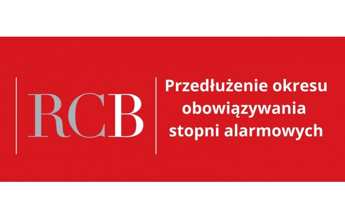 Czerwone tło, po lewej stronie duży jasnoszary skrót „RCB”, po prawej stronie biały tekst: „Przedłużenie okresu obowiązywania stopni alarmowych”. Po obu stronach napisu znajdują się pionowe białe linie oddzielające elementy.
