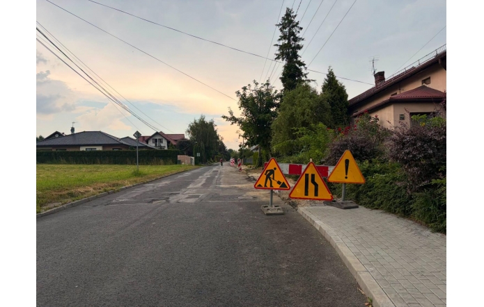 Droga asfaltowa oznaczona znakami drogowymi informującymi o remoncie i utrudnieniach w ruchu.